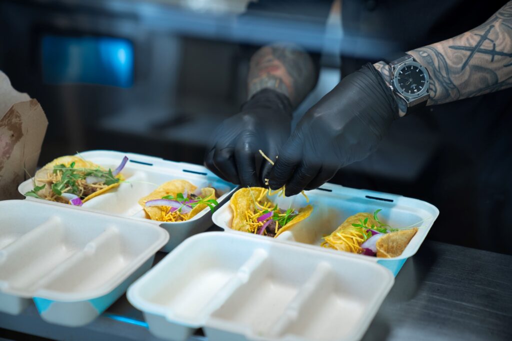 Chef assembling bang bang tacos at Balance Grille, showcasing bold, fast casual catering flavors.