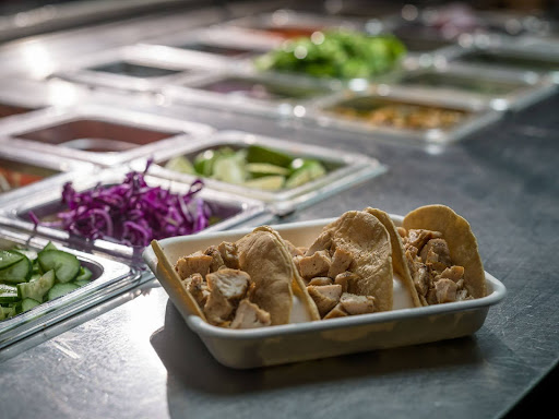 Tray of seasoned chicken tacos at Balance Grille with visible fresh toppings and ingredients on prep counter in Cleveland.