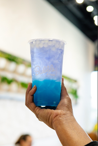 A man holding a glass of bubble tea from Balance Grille.