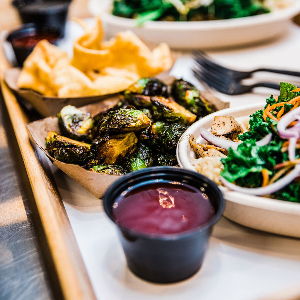 Balance Grille tray with Citrus Brussels, a Build Your Bowl, Eggie Bowl, and creamy dish in Cleveland, OH.