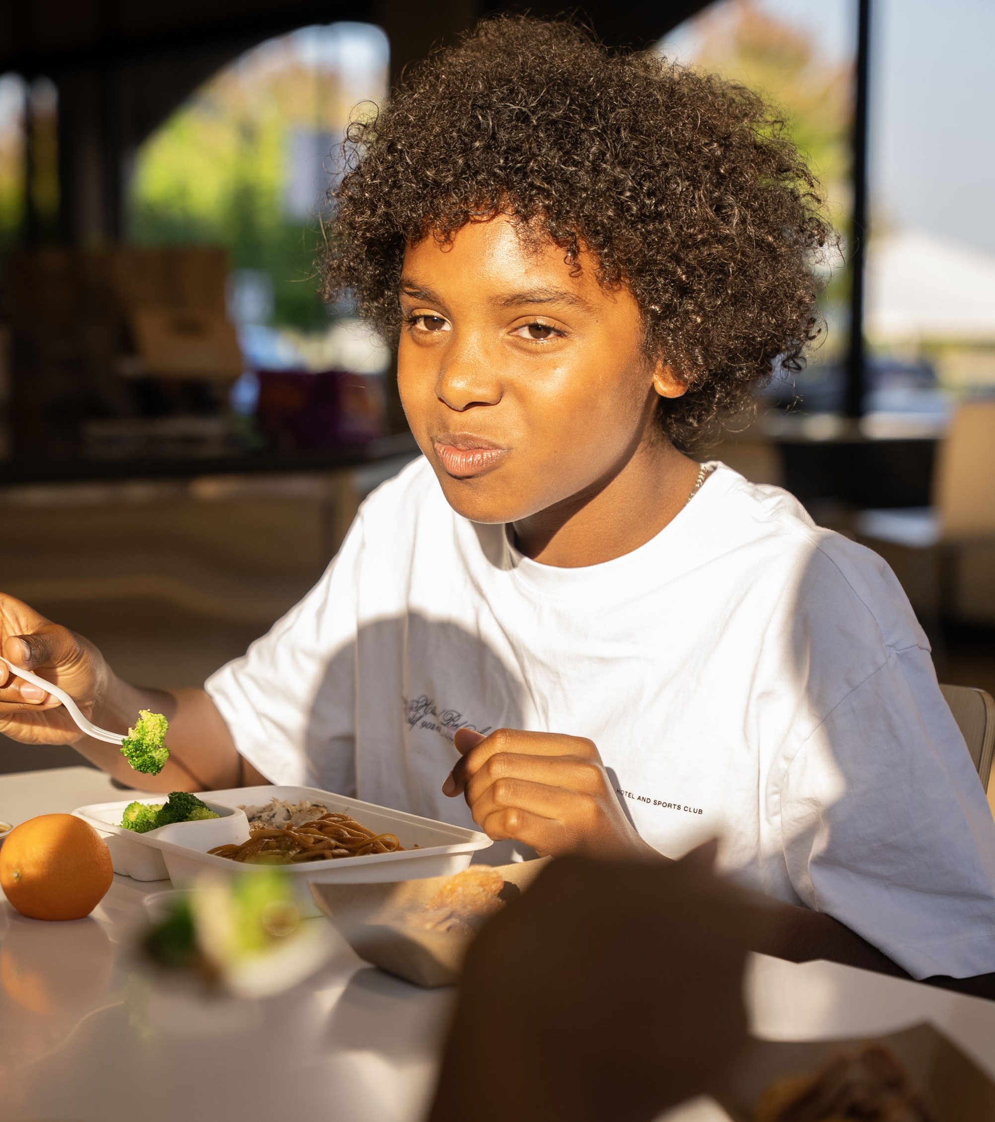 A small boy happily enjoying the kids’ meal at Balance Grille, along with his friends.